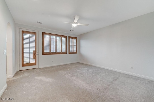 unfurnished room with light carpet, baseboards, visible vents, and a ceiling fan