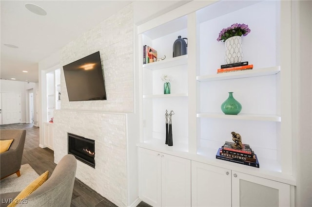 bar featuring recessed lighting, built in shelves, dark wood-style flooring, and a glass covered fireplace