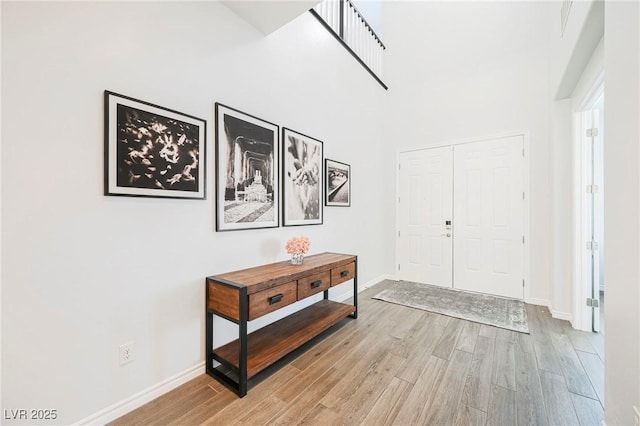 foyer featuring light wood-style flooring and baseboards