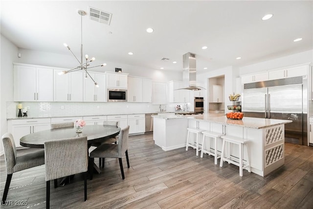 dining room with light wood-style floors, recessed lighting, visible vents, and an inviting chandelier