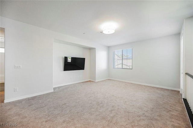 unfurnished living room featuring light carpet and baseboards