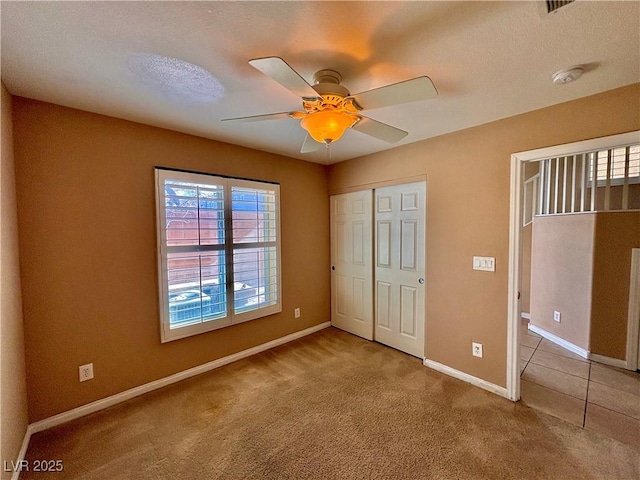 unfurnished bedroom with ceiling fan, a closet, and carpet