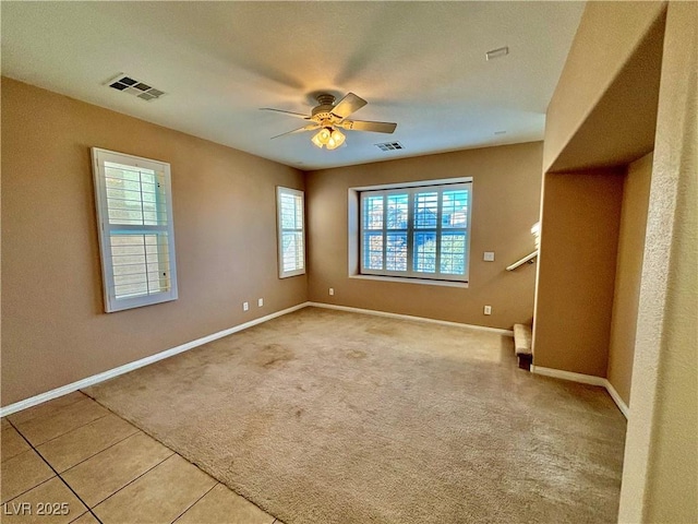 carpeted spare room featuring ceiling fan