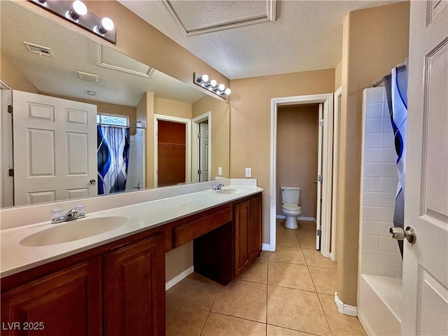 bathroom featuring vanity, a textured ceiling, tile patterned floors, and toilet