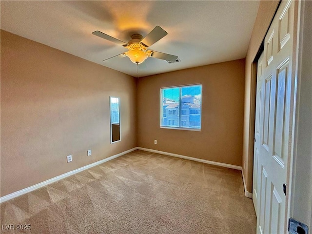 carpeted empty room featuring ceiling fan