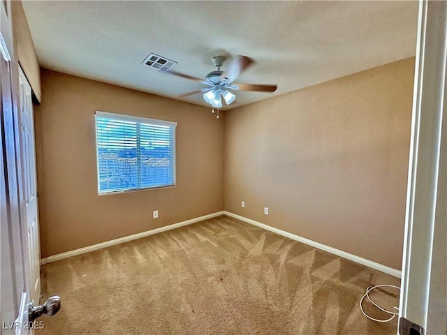 empty room featuring ceiling fan and light colored carpet