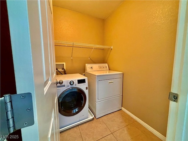 laundry room featuring separate washer and dryer and light tile patterned floors