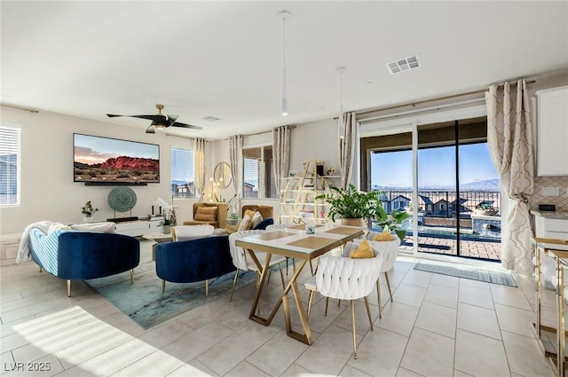 tiled dining area with ceiling fan