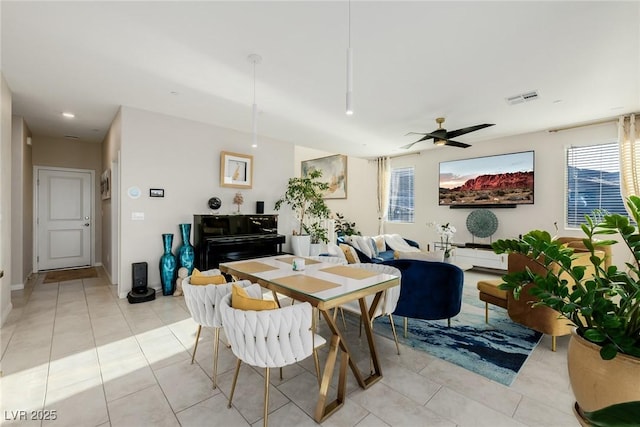 dining space with ceiling fan and light tile patterned flooring