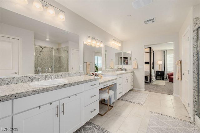 bathroom featuring an enclosed shower, vanity, a wealth of natural light, and tile patterned floors