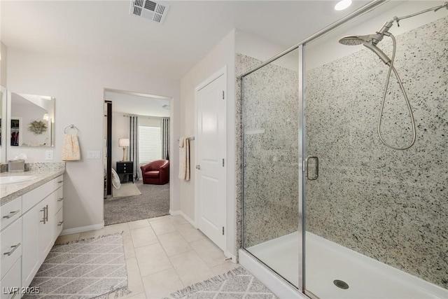 bathroom featuring tile patterned flooring, vanity, and a shower with shower door