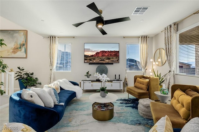 living area featuring light tile patterned floors and ceiling fan