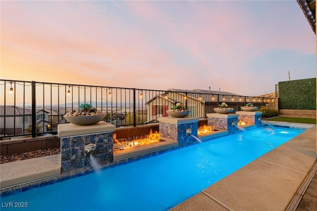 pool at dusk with pool water feature