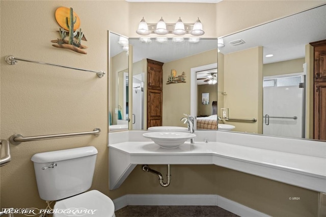 bathroom with an enclosed shower, sink, and toilet