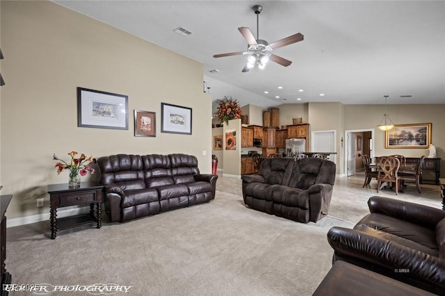 living room featuring lofted ceiling, light colored carpet, and ceiling fan