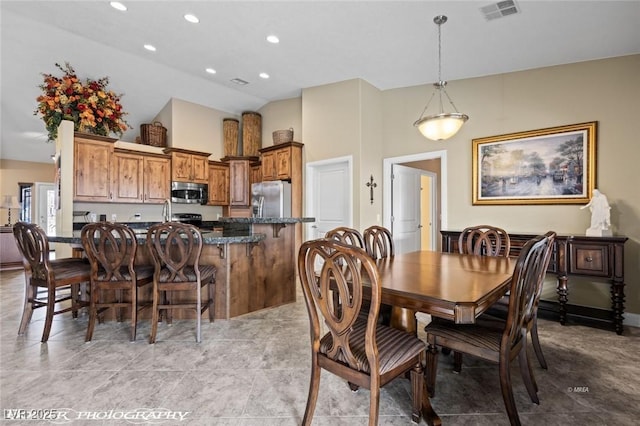 dining space featuring light tile patterned floors and high vaulted ceiling