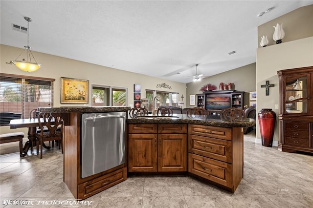 kitchen featuring lofted ceiling, sink, a center island, hanging light fixtures, and stainless steel dishwasher