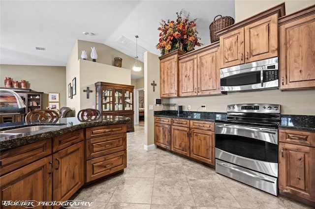 kitchen with appliances with stainless steel finishes and dark stone countertops