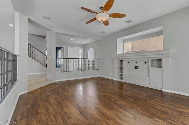 unfurnished living room with stairs, wood finished floors, visible vents, and baseboards