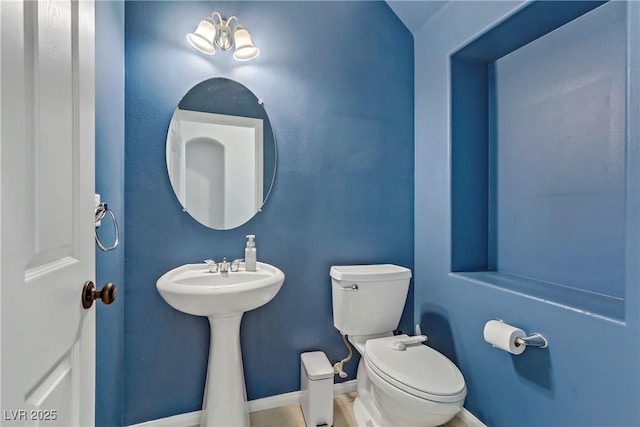 bathroom featuring toilet and baseboards