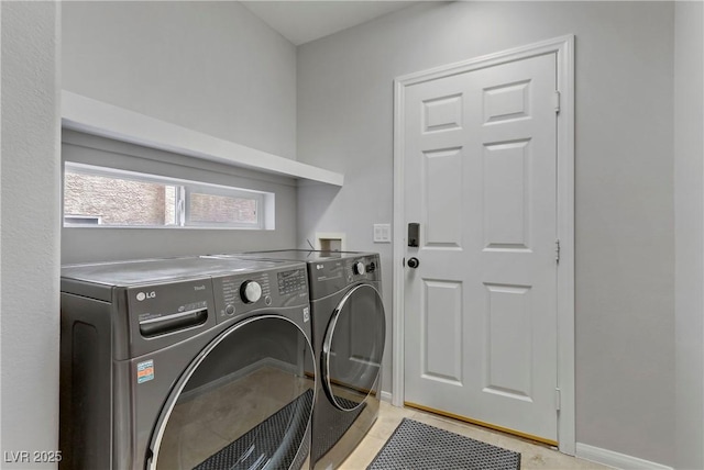 laundry room with laundry area, baseboards, and washer and dryer