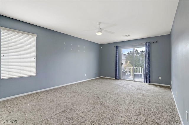 carpeted empty room featuring visible vents, baseboards, and a ceiling fan