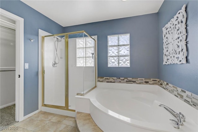 full bath with a shower stall, baseboards, a bath, and tile patterned floors