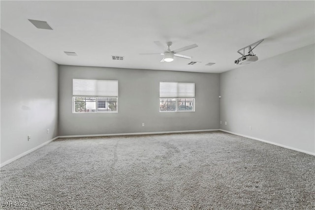 carpeted empty room with ceiling fan, visible vents, and a healthy amount of sunlight