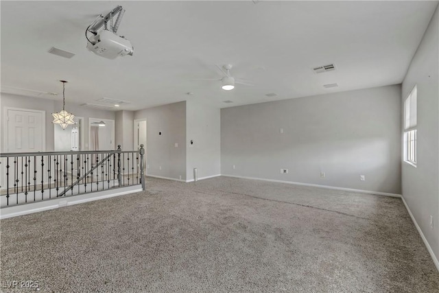 unfurnished room featuring carpet flooring, visible vents, and baseboards