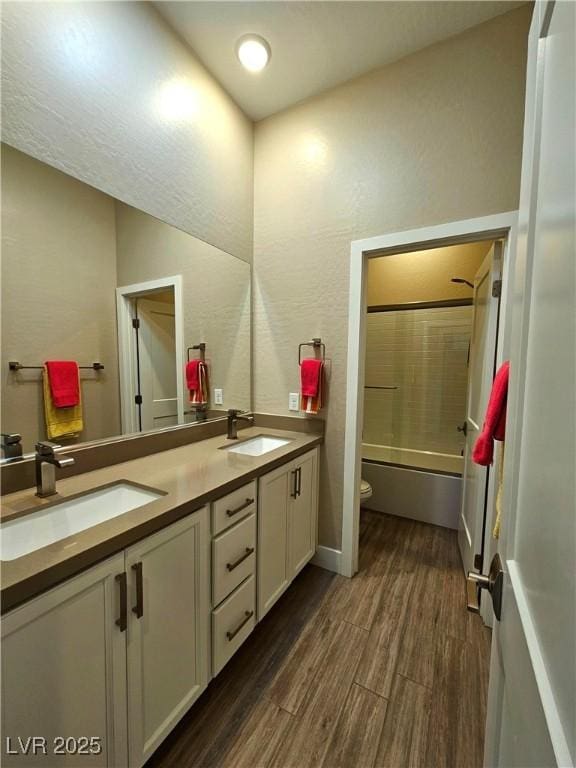 full bathroom with hardwood / wood-style flooring, vanity, shower / washtub combination, and toilet