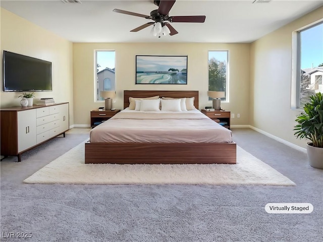 carpeted bedroom featuring multiple windows and ceiling fan