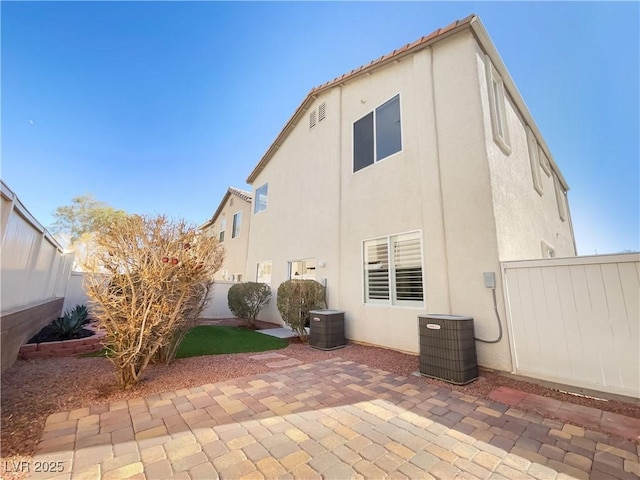 rear view of house featuring central AC unit and a patio