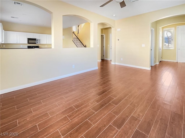 unfurnished living room featuring dark hardwood / wood-style flooring and ceiling fan