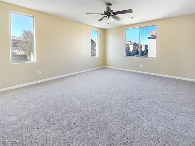 unfurnished room with ceiling fan and carpet