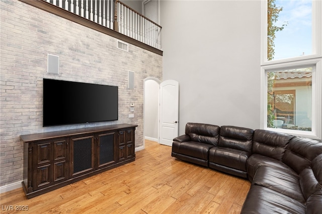 living room with light hardwood / wood-style flooring and a high ceiling