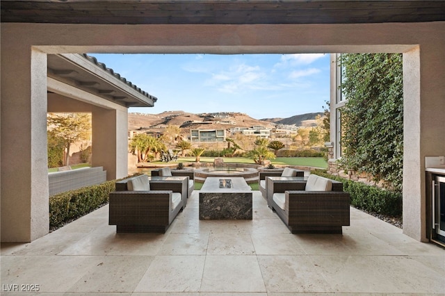 view of patio featuring a mountain view and an outdoor living space with a fire pit