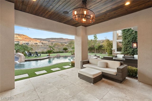 view of patio / terrace with an outdoor living space, ceiling fan, a mountain view, and pool water feature