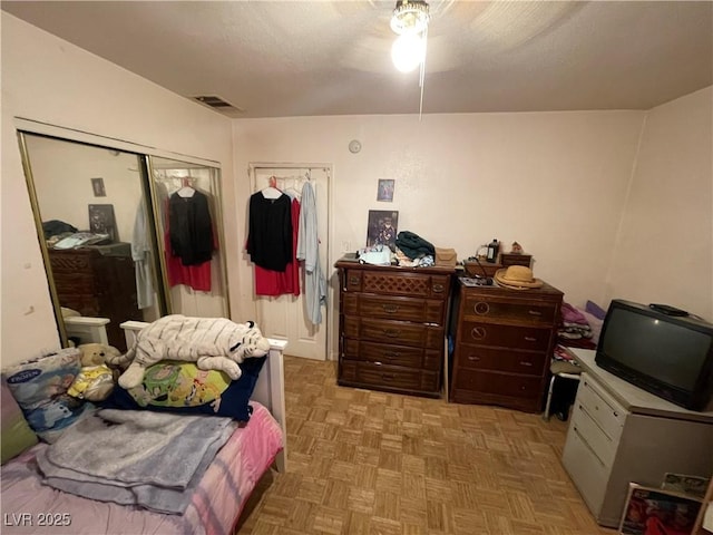 bedroom with a textured ceiling, a closet, and light parquet flooring