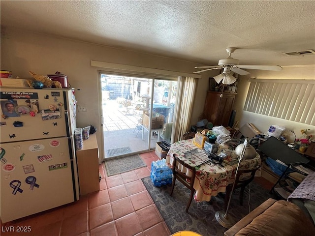 dining space with ceiling fan, tile patterned floors, and a textured ceiling