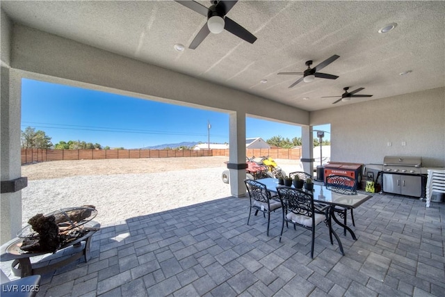 view of patio / terrace with a hot tub, area for grilling, and ceiling fan