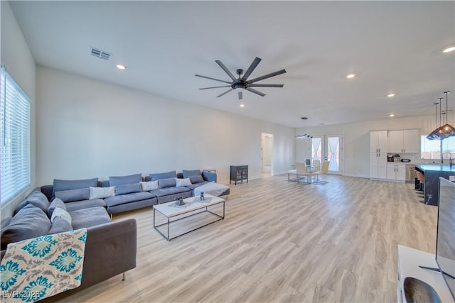 living room with ceiling fan, light wood-type flooring, and french doors