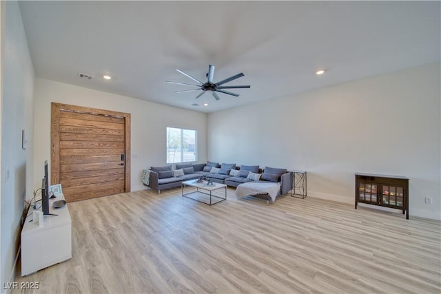 living room featuring ceiling fan and light hardwood / wood-style floors