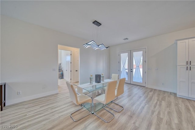 dining space featuring french doors and light wood-type flooring