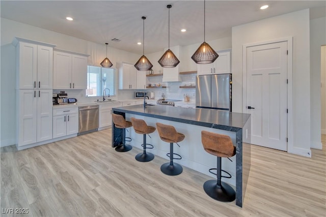 kitchen featuring white cabinetry, a kitchen island, and appliances with stainless steel finishes