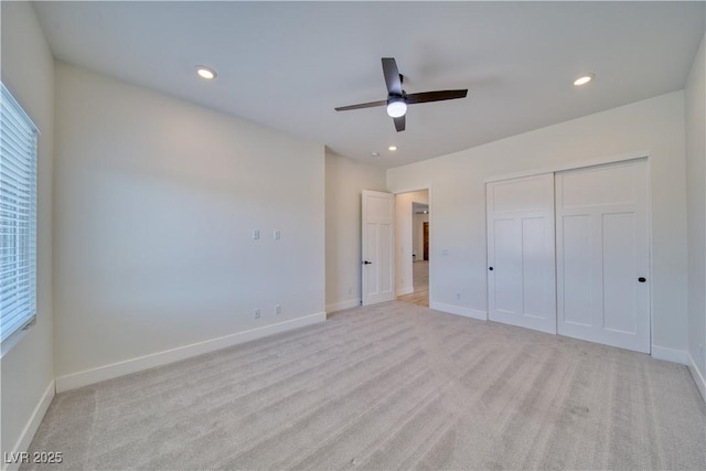 unfurnished bedroom featuring light colored carpet, ceiling fan, and a closet