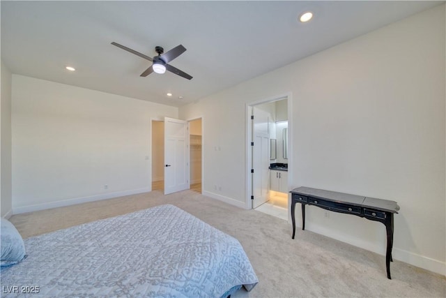 carpeted bedroom with connected bathroom, a walk in closet, and ceiling fan