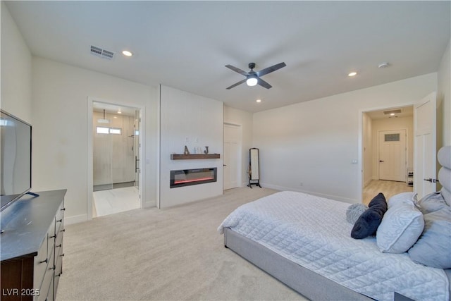 carpeted bedroom featuring ceiling fan and ensuite bath