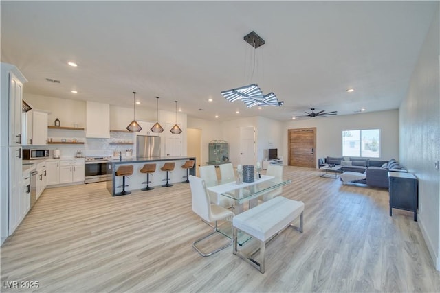 living room featuring ceiling fan and light hardwood / wood-style floors