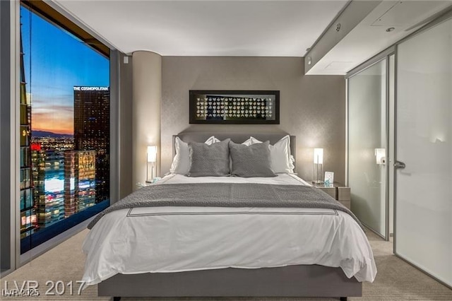 carpeted bedroom with a wall of windows