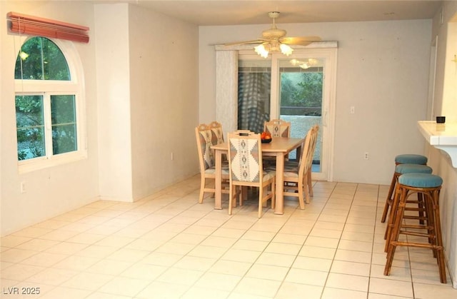 tiled dining space featuring plenty of natural light and ceiling fan